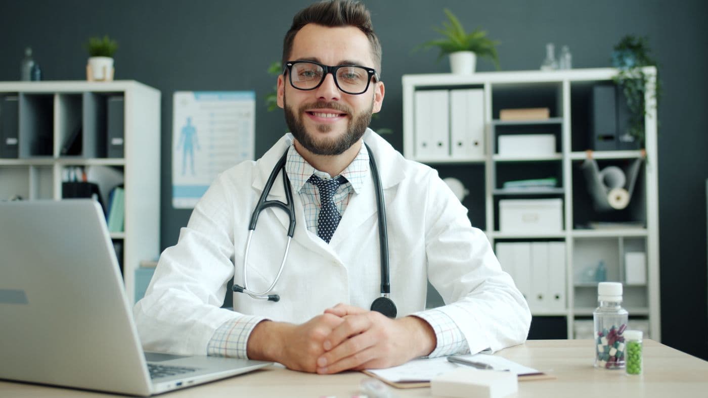 A clinician smiling at a consultation desk