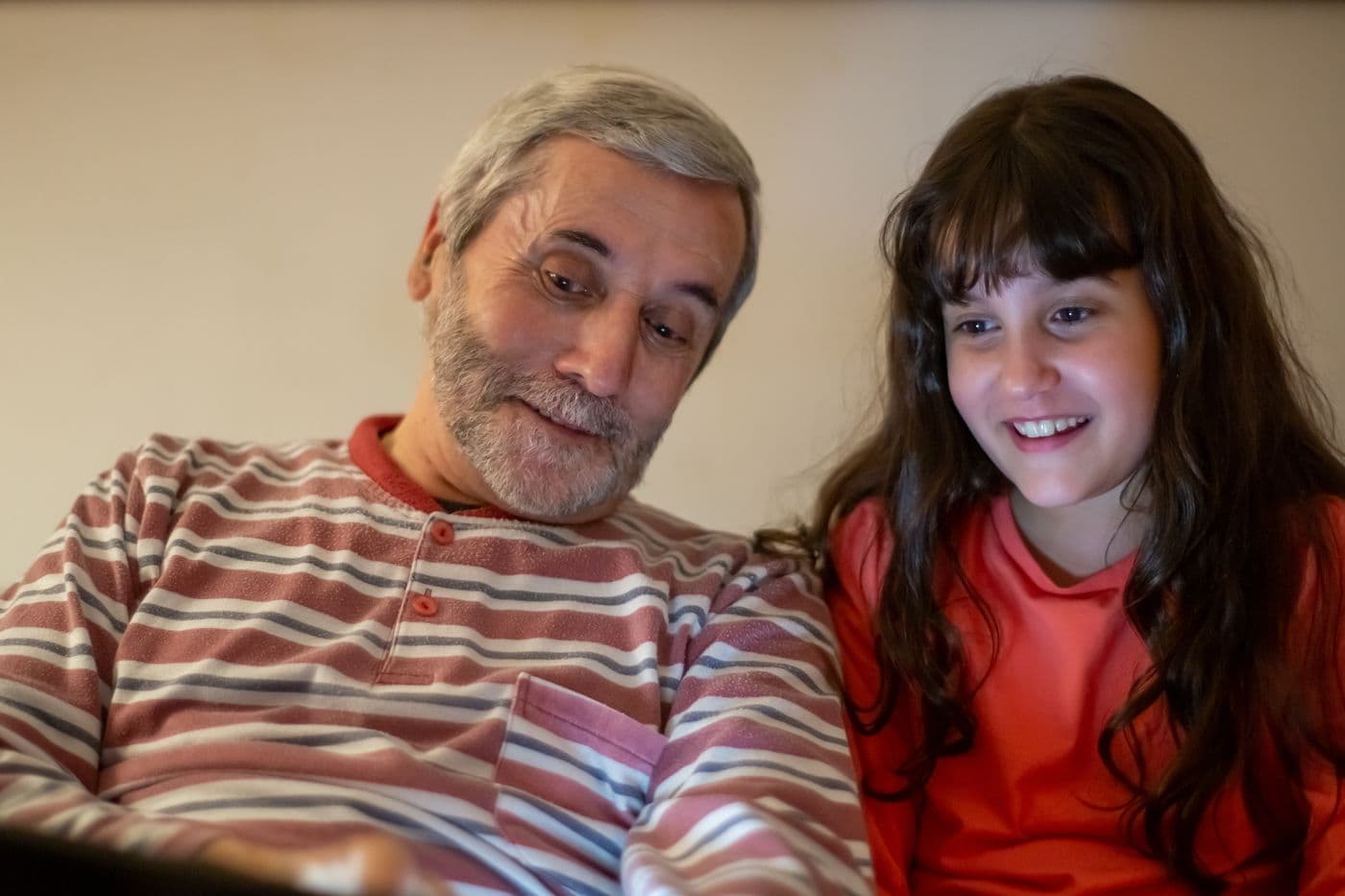 A grandfather and his granddaughter laughing together