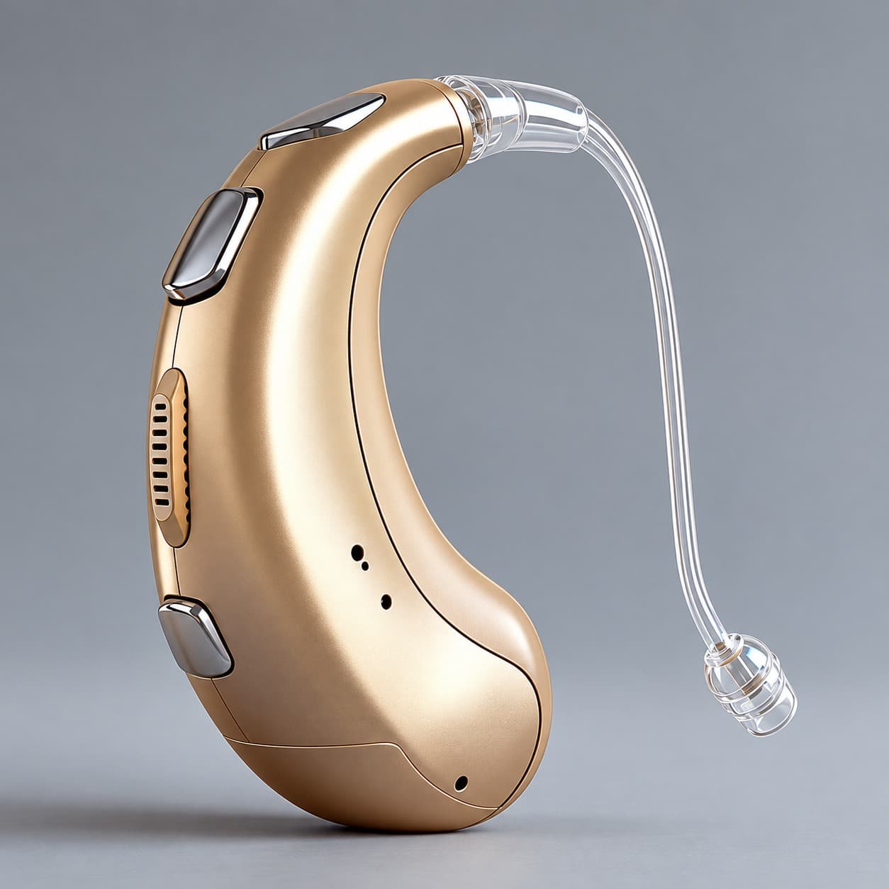 A gold behind-the-ear hearing aid with a clear receiver wire and ear dome